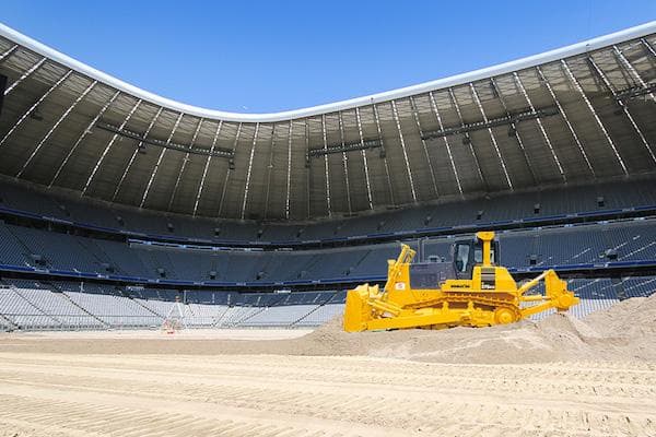 Bulldozer étalant du sable dans un stade